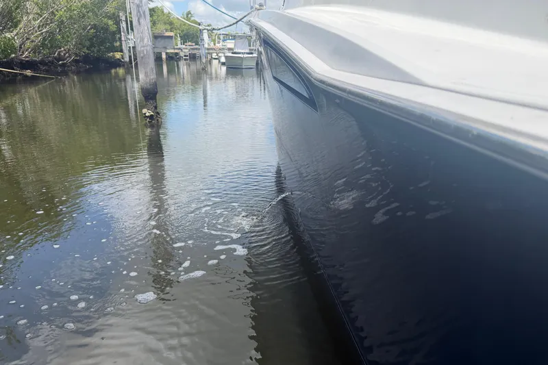 Slide: The Image of Cabo 35 Flybridge 2000 boat docked in calm waters, side view. - 23