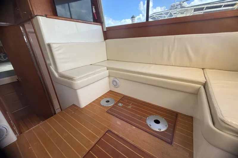 Slide: The Image of Interior of 2000 Cabo 35 Flybridge with cream seating and wooden flooring. - 74