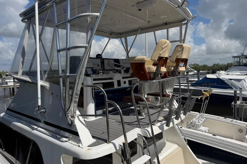 Slide: The Image of 2000 Cabo 35 Flybridge boat with elevated helm and seating at marina. - 5