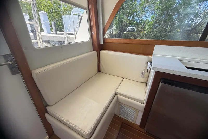 Slide: The Image of Interior seating area of a 2000 Cabo 35 Flybridge boat with cream cushions. - 66