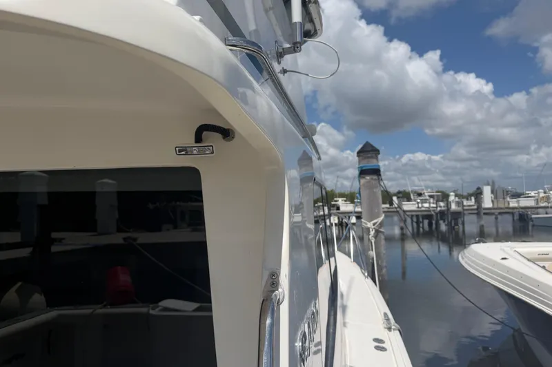 Slide: The Image of Cabo 35 Flybridge 2000 yacht docked at marina under cloudy sky. - 30