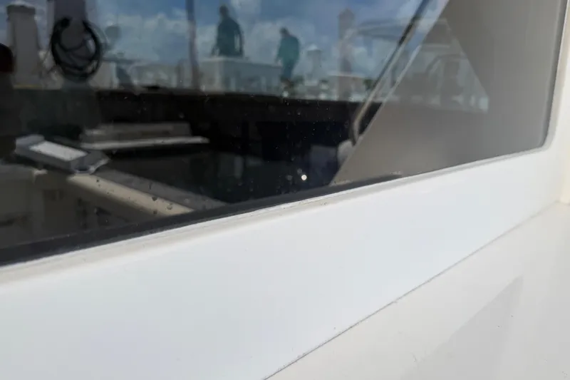Slide: The Image of Close-up of Cabo 35 Flybridge boat window, reflecting marina scene, 2000 model. - 35