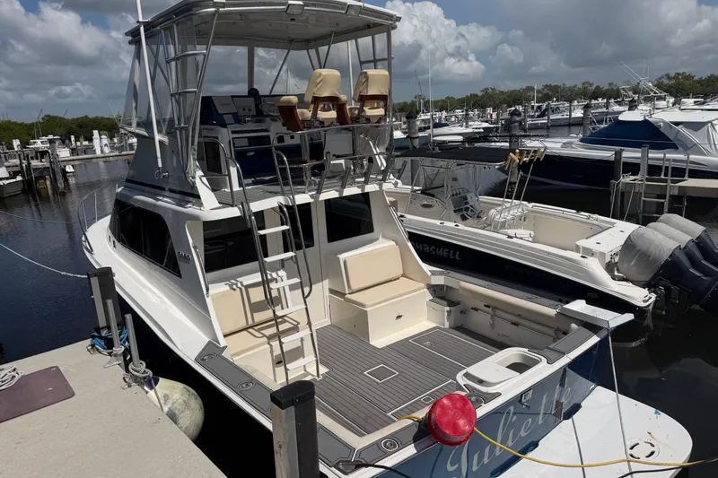 Slide: The Image of Cabo 35 Flybridge 2000 yacht docked at marina, featuring spacious deck and flybridge. - 3
