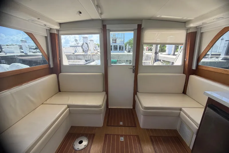 Slide: The Image of Interior of 2000 Cabo 35 Flybridge yacht with white seating and wooden flooring. - 61