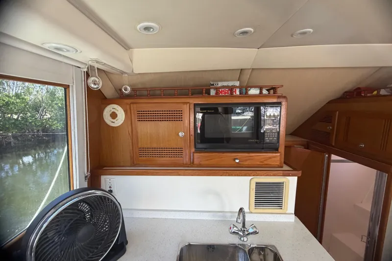 Slide: The Image of Interior of 2000 Cabo 35 Flybridge with microwave, fan, and sink. - 71