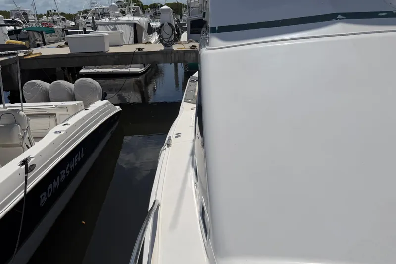 Slide: The Image of Docked Cabo 35 Flybridge boat from 2000, alongside other vessels at a marina. - 42