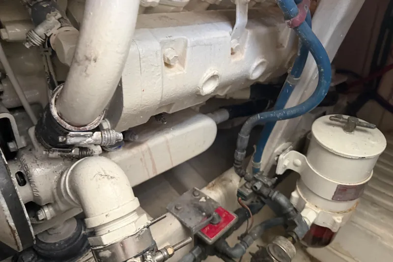 Slide: The Image of Engine compartment of a 2000 Cabo 35 Flybridge boat, showcasing pipes and components. - 100