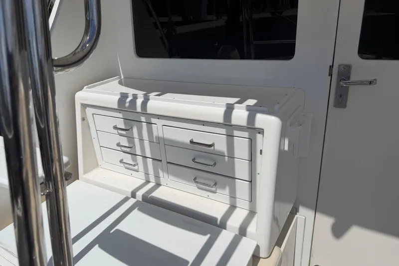 Slide: The Image of White storage drawers on a 2000 Cabo 35 Flybridge boat deck. - 53