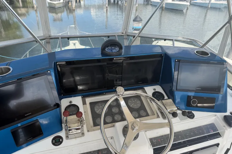 Slide: The Image of Helm of 2000 Cabo 35 Flybridge with navigation screens and steering wheel, docked at marina. - 11