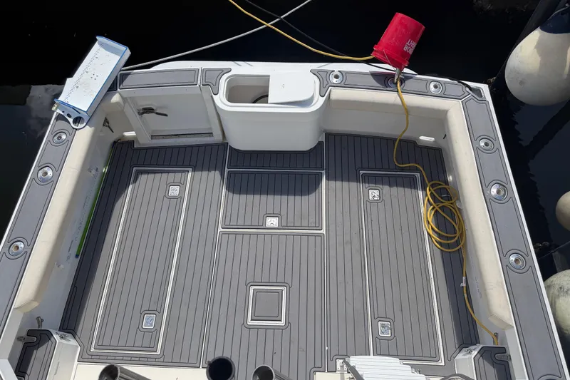 Slide: The Image of 2000 Cabo 35 Flybridge boat deck with fishing rod holders and storage compartments. - 17
