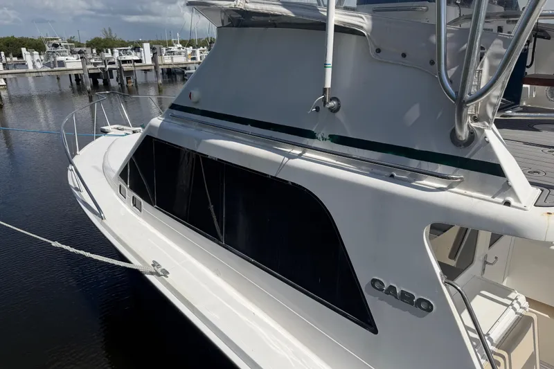 Slide: The Image of 2000 Cabo 35 Flybridge boat docked at marina, side view. - 6