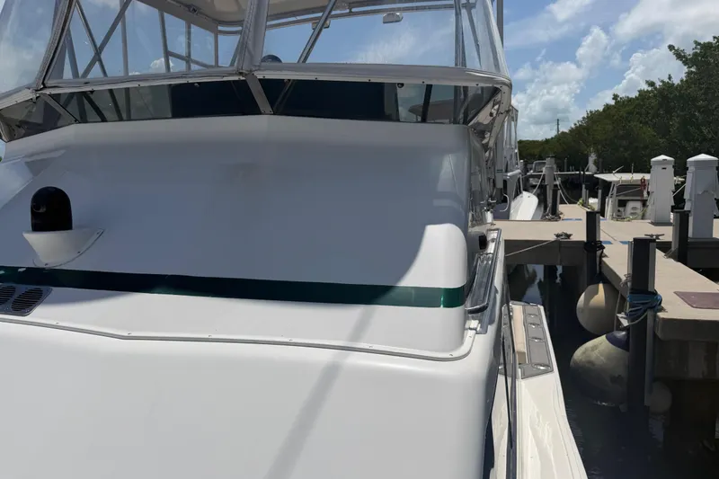 Slide: The Image of Cabo 35 Flybridge 2000 yacht docked at marina under clear sky. - 41