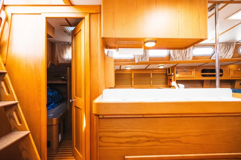 Slide: The Image of Interior of 1985 Hinckley Sou'wester 51 yacht with wooden cabinetry and cozy sleeping quarters. - 26