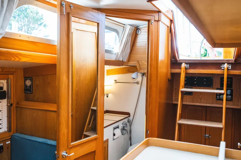 Slide: The Image of Interior of 1985 Hinckley Sou'wester 51 sailboat, featuring wooden cabinetry and ladder. - 28