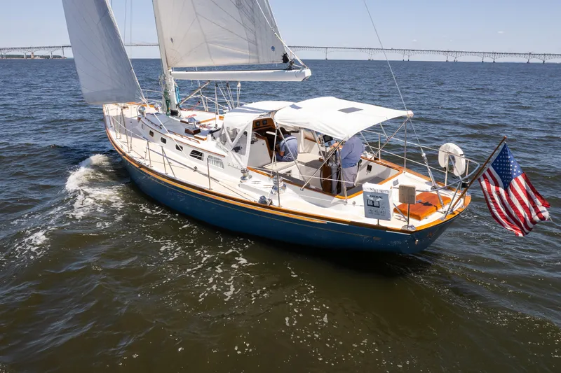 Slide: The Image of 1985 Hinckley Sou'wester 51 sailboat cruising on open water with American flag. - 63