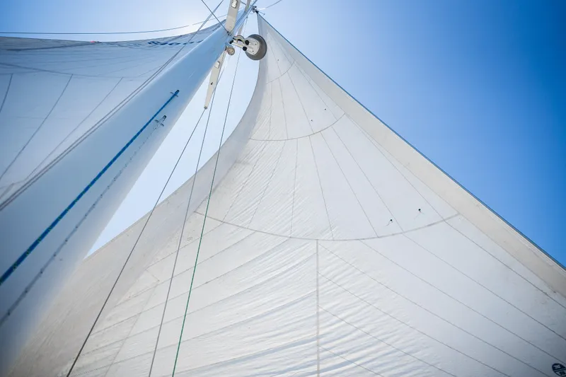 Slide: The Image of Sails of a 1985 Hinckley Sou'wester 51 yacht against a clear blue sky. - 57