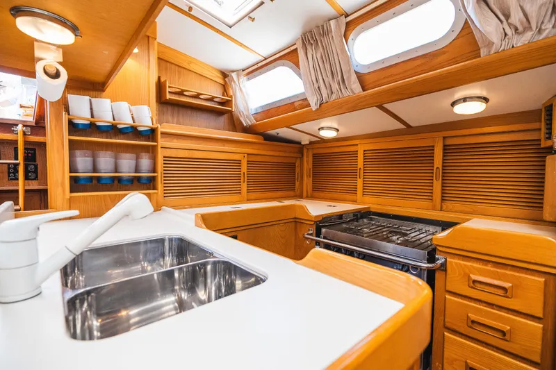 Slide: The Image of Interior of 1985 Hinckley Sou'wester 51 yacht kitchen with wooden cabinetry and stainless steel sink. - 12