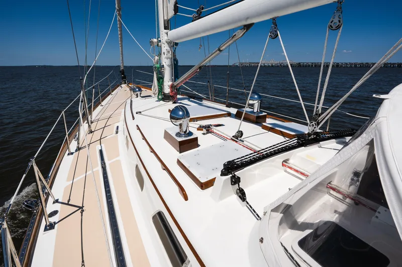 Slide: The Image of Hinckley Sou'wester 51 sailboat deck, 1985 model, cruising on open water under clear blue skies. - 56