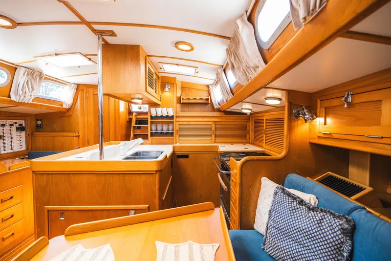 Slide: The Image of Interior of 1985 Hinckley Sou'wester 51 yacht, featuring wooden cabinetry and cozy seating. - 21