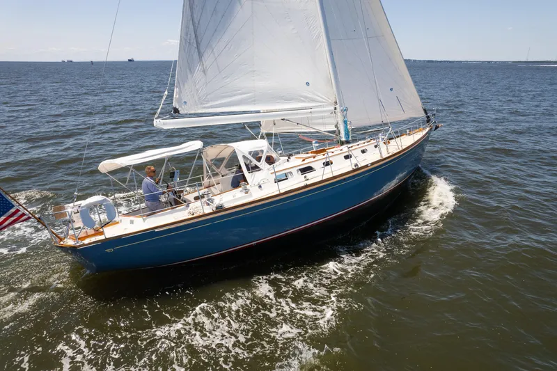 Slide: The Image of 1985 Hinckley Sou'wester 51 sailboat cruising on open water under clear skies. - 62
