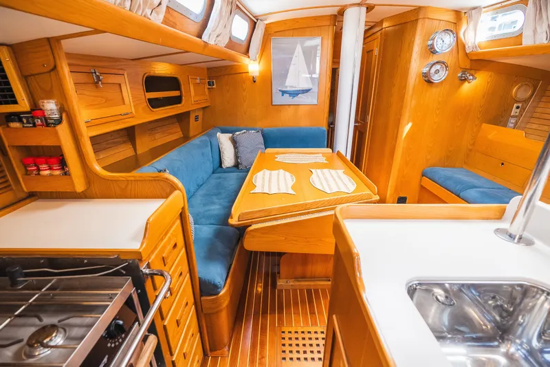 Slide: The Image of Interior of 1985 Hinckley Sou'wester 51 yacht with wooden furnishings and blue seating. - 18