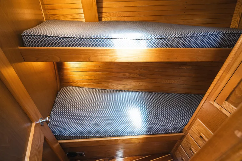 Slide: The Image of Wooden bunk beds with blue patterned cushions on a 1985 Hinckley Sou'wester 51 yacht. - 22