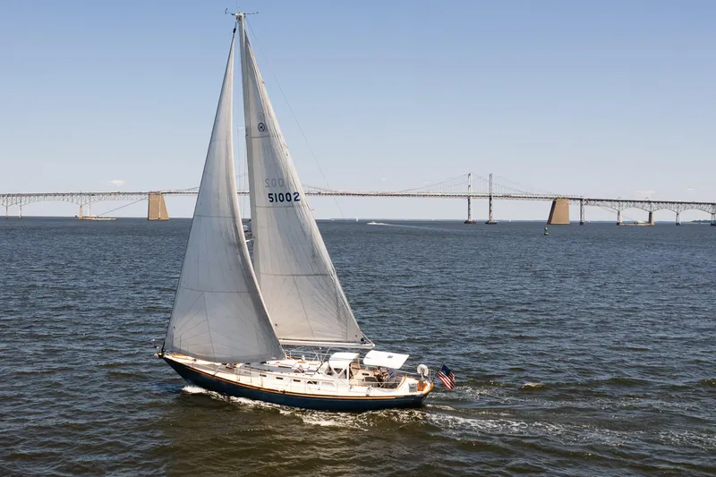 The Image of Hinckley Sou'wester 51 sailboat cruising near a bridge on a sunny day, 1985 model. - 0