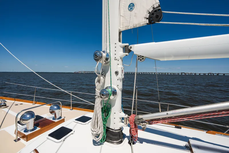Slide: The Image of Hinckley Sou'wester 51 sailboat deck with mast and rigging, ocean view, clear blue sky. - 44