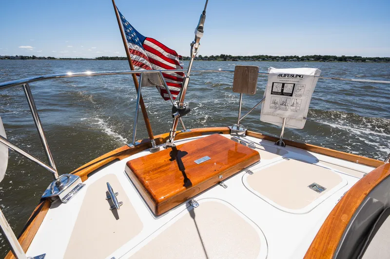Slide: The Image of Hinckley Sou'wester 51 sailboat deck with American flag, cruising on open water, 1985 model. - 61