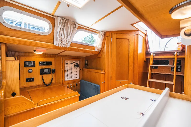 Slide: The Image of Interior of 1985 Hinckley Sou'wester 51 sailboat, featuring wooden cabinetry and navigation equipment. - 13