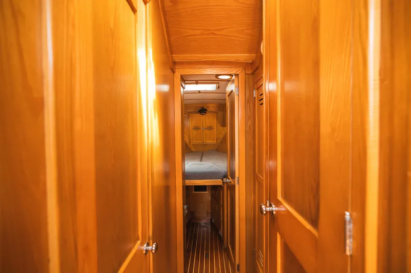 Slide: The Image of Hinckley Sou'wester 51 yacht interior, featuring wooden hallway and cozy cabin, 1985 model. - 24