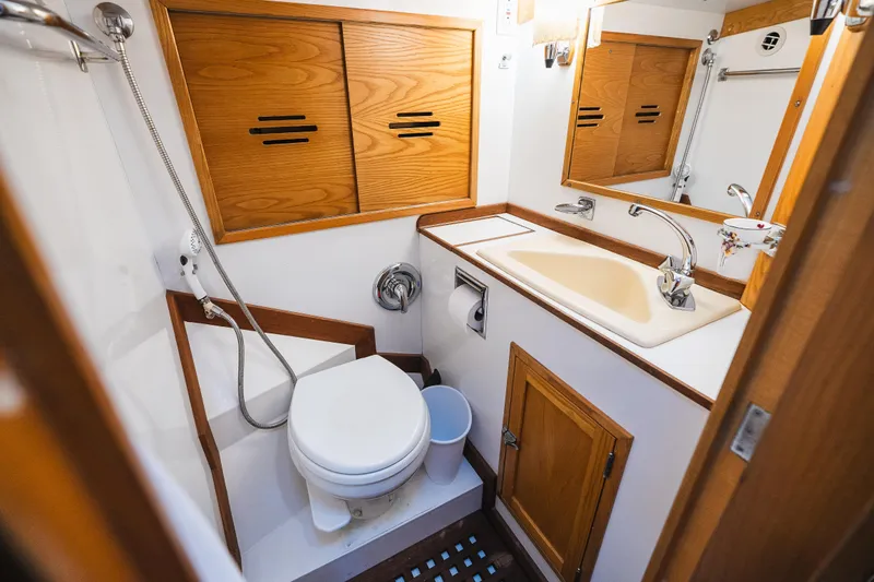 Slide: The Image of Hinckley Sou'wester 51 yacht bathroom, 1985 model, featuring wooden cabinetry and compact design. - 23