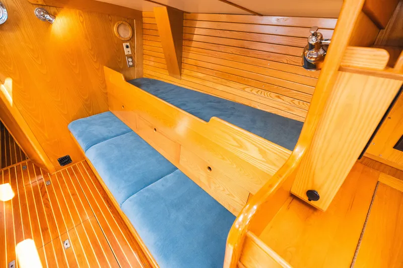 Slide: The Image of Interior of 1985 Hinckley Sou'wester 51 yacht with wooden finish and blue cushions. - 17