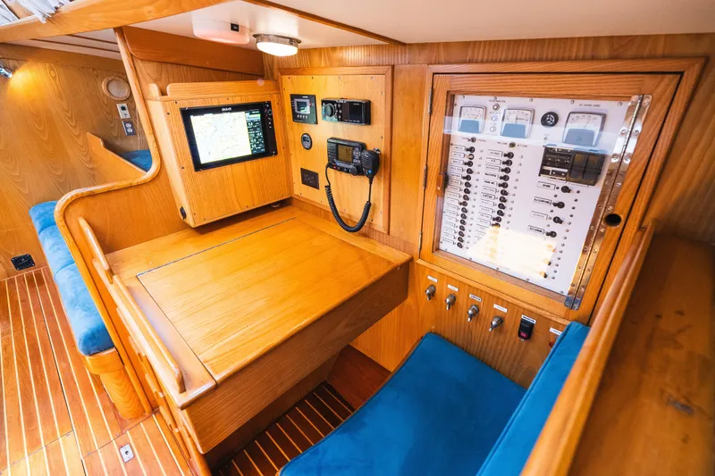 Slide: The Image of Navigation station of 1985 Hinckley Sou'wester 51 yacht with control panels and seating. - 15