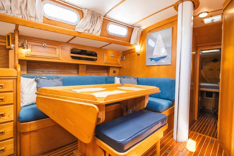 Slide: The Image of Interior of 1985 Hinckley Sou'wester 51 yacht with wooden furnishings and blue seating. - 20