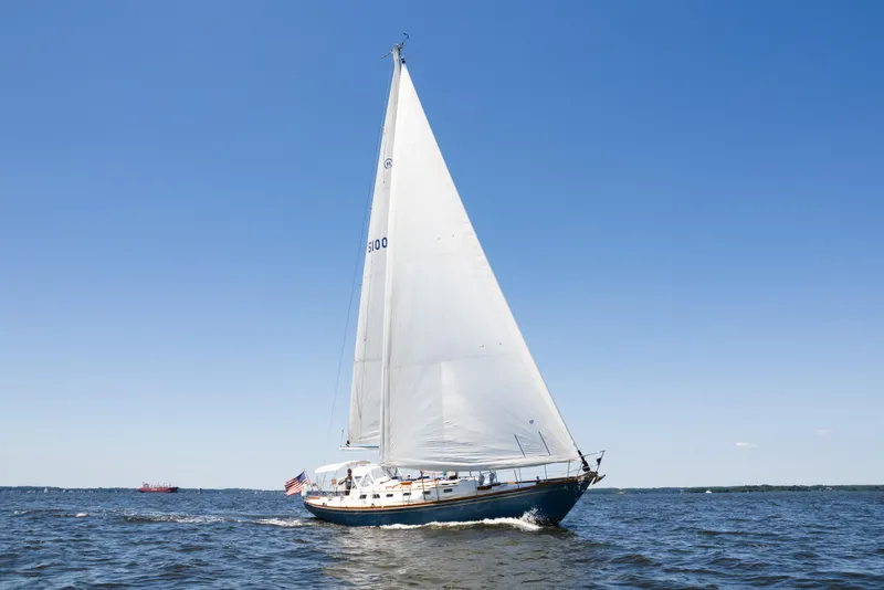 Slide: The Image of 1985 Hinckley Sou'wester 51 sailboat cruising on open water under clear blue skies. - 66