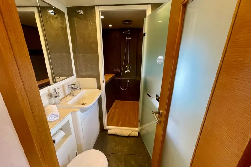 Slide: The Image of Modern bathroom interior on Serenity 64 yacht, featuring sleek fixtures and a glass shower door. - 59
