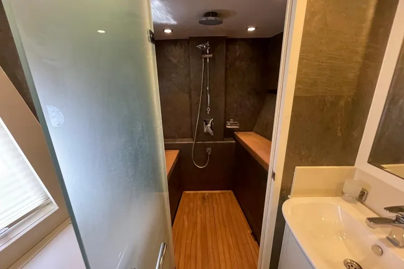 Slide: The Image of Modern bathroom with glass door, wooden flooring, and sleek shower fixtures in a 2018 Serenity 64. - 41