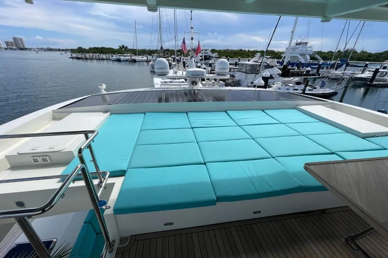 Slide: The Image of Luxurious Serenity 64 yacht deck with turquoise cushions, docked at a marina, 2018 model. - 14