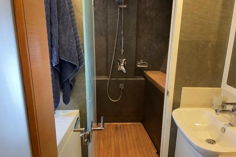 Slide: The Image of Modern bathroom with wooden flooring, glass shower door, and sleek fixtures on a Serenity 64 yacht. - 34