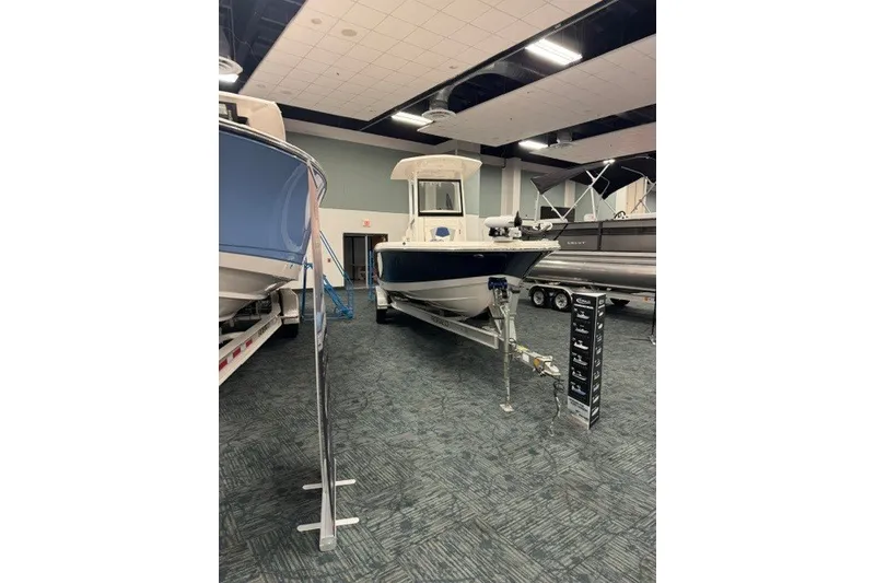 The Image of 2026 Robalo 246 Cayman boat displayed indoors on a trailer. - 0