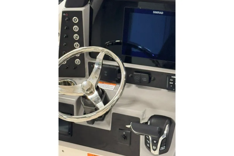 Slide: The Image of 2026 Robalo 246 Cayman boat dashboard with steering wheel and Simrad display. - 13