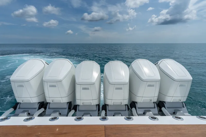 Slide: The Image of Five powerful outboard engines on a 2023 HCB 65 Estrella yacht, cruising on open sea. - 53