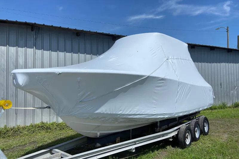 Slide: The Image of 2027 Sportsman Heritage 231 Center Console boat covered on a trailer, parked outdoors. - 1