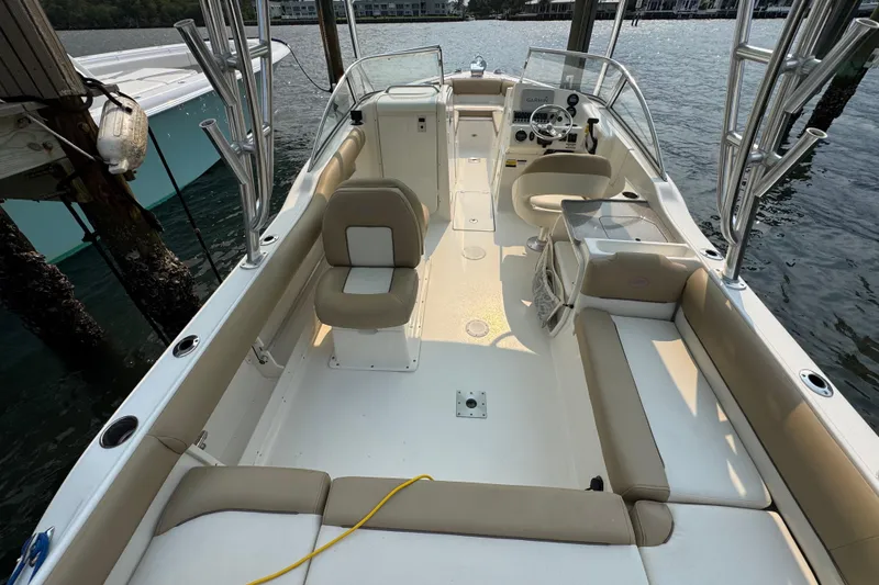 Slide: The Image of 2019 Key West 239 DFS boat interior with beige seating, docked by the water. - 4