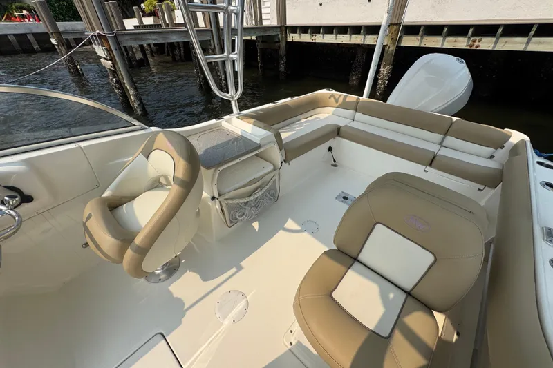 Slide: The Image of 2019 Key West 239 DFS boat interior with beige seating and steering wheel. - 7