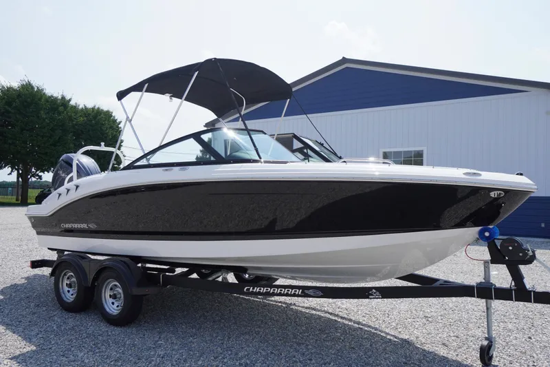 Slide: The Image of 2026 Chaparral 21 SSi OB boat on trailer, black and white design, parked outdoors. - 59