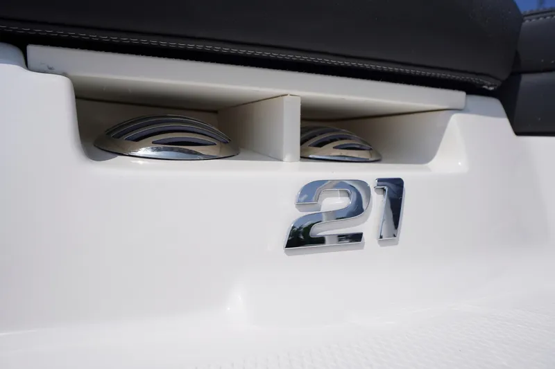 Slide: The Image of 2026 Chaparral 21 SSi OB boat detail with chrome "21" emblem and sleek design elements. - 47
