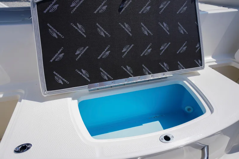 Slide: The Image of 2026 Chaparral 21 SSi OB boat storage compartment with open lid, featuring branded interior. - 34