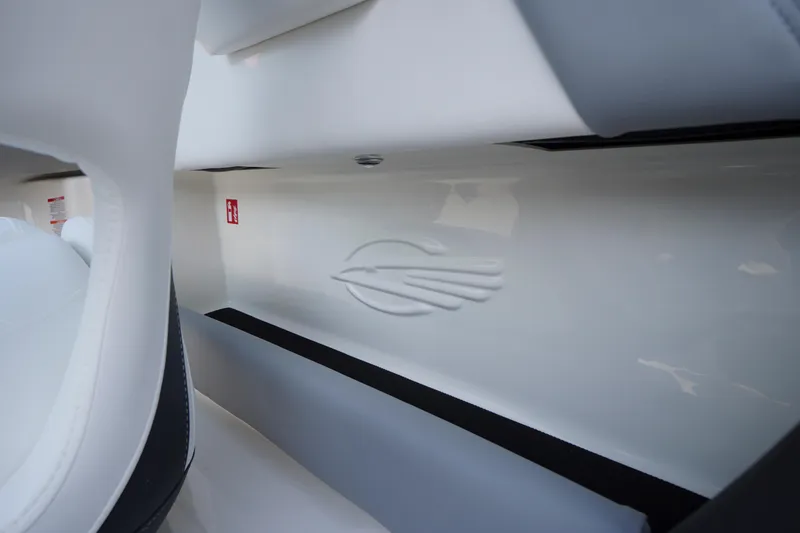 Slide: The Image of Interior detail of 2026 Chaparral 21 SSi OB boat, featuring sleek white design and logo. - 24